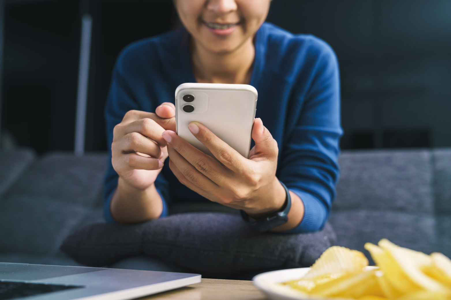 woman using phone in living room at night